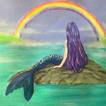 mermaid on rock with a rainbow in the distance